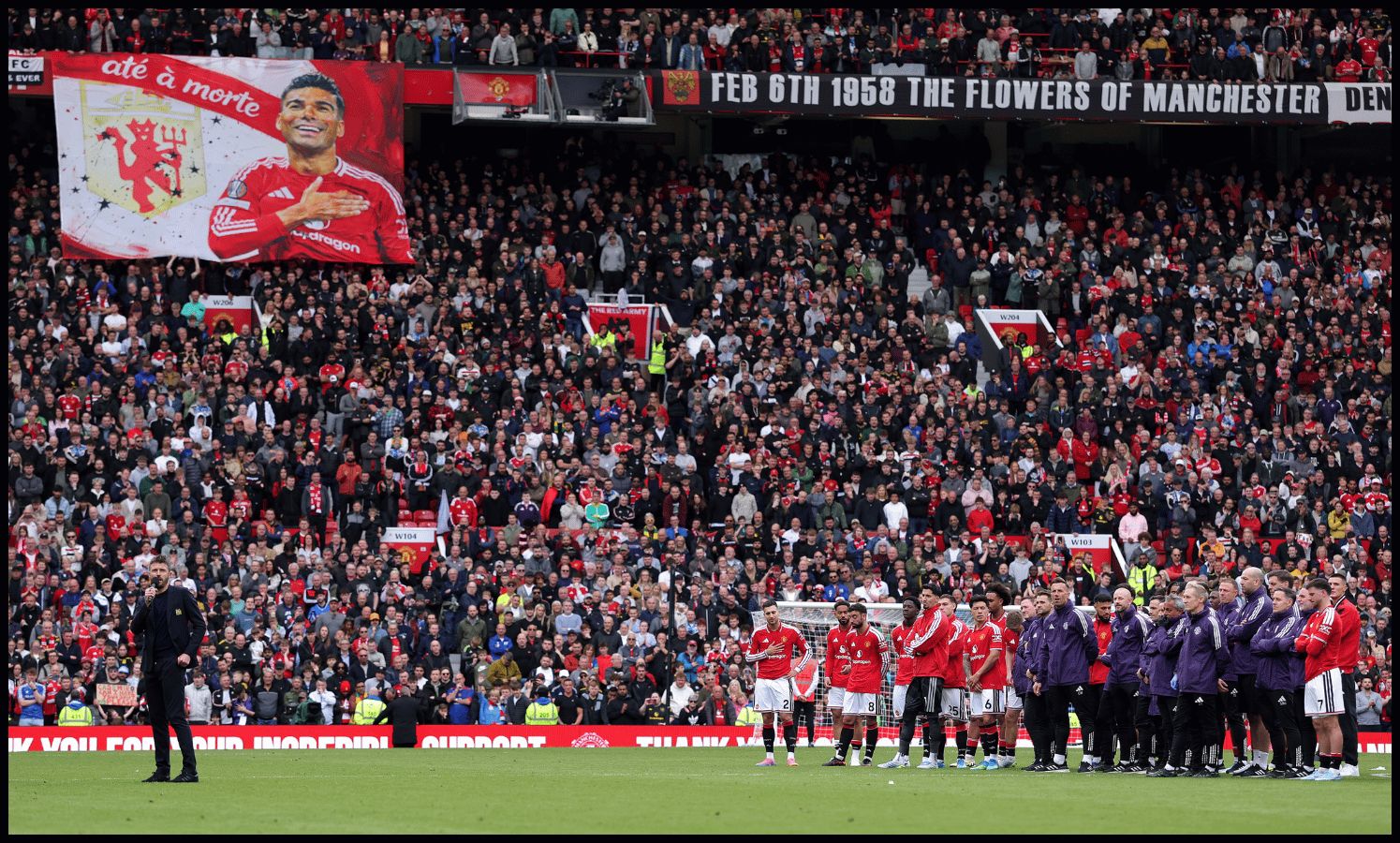 MANCHESTER, ENGLAND - MAY 17: Michael Carrick, Manager of Manchester United, speaks to the fans as a banner tribute to Casemiro of Manchester United is seen in the stands following the Premier League match between Manchester United and Nottingham Forest at Old Trafford on May 17, 2026 in Manchester, England.