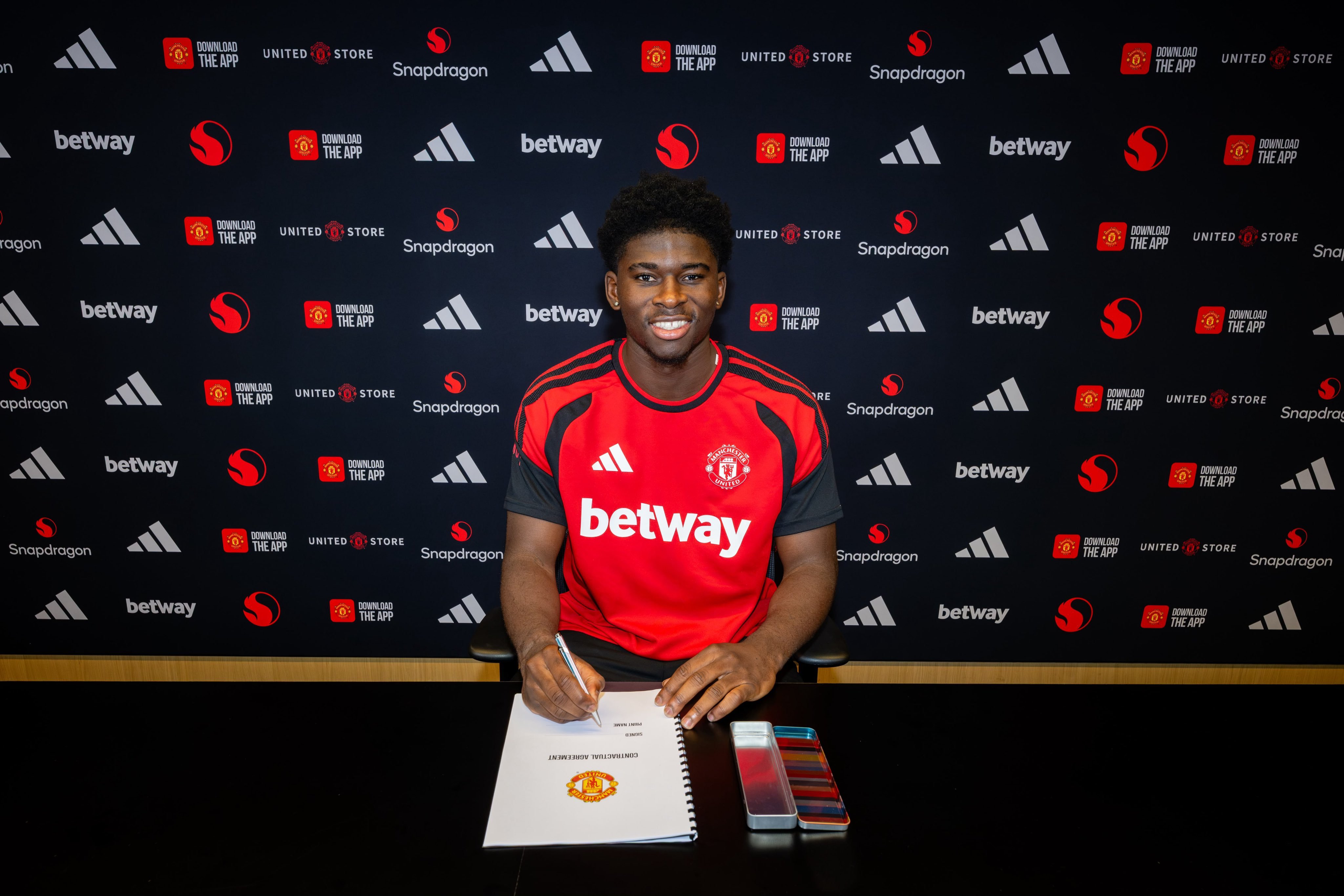 Carlos Baleba signs hia Man United contract.