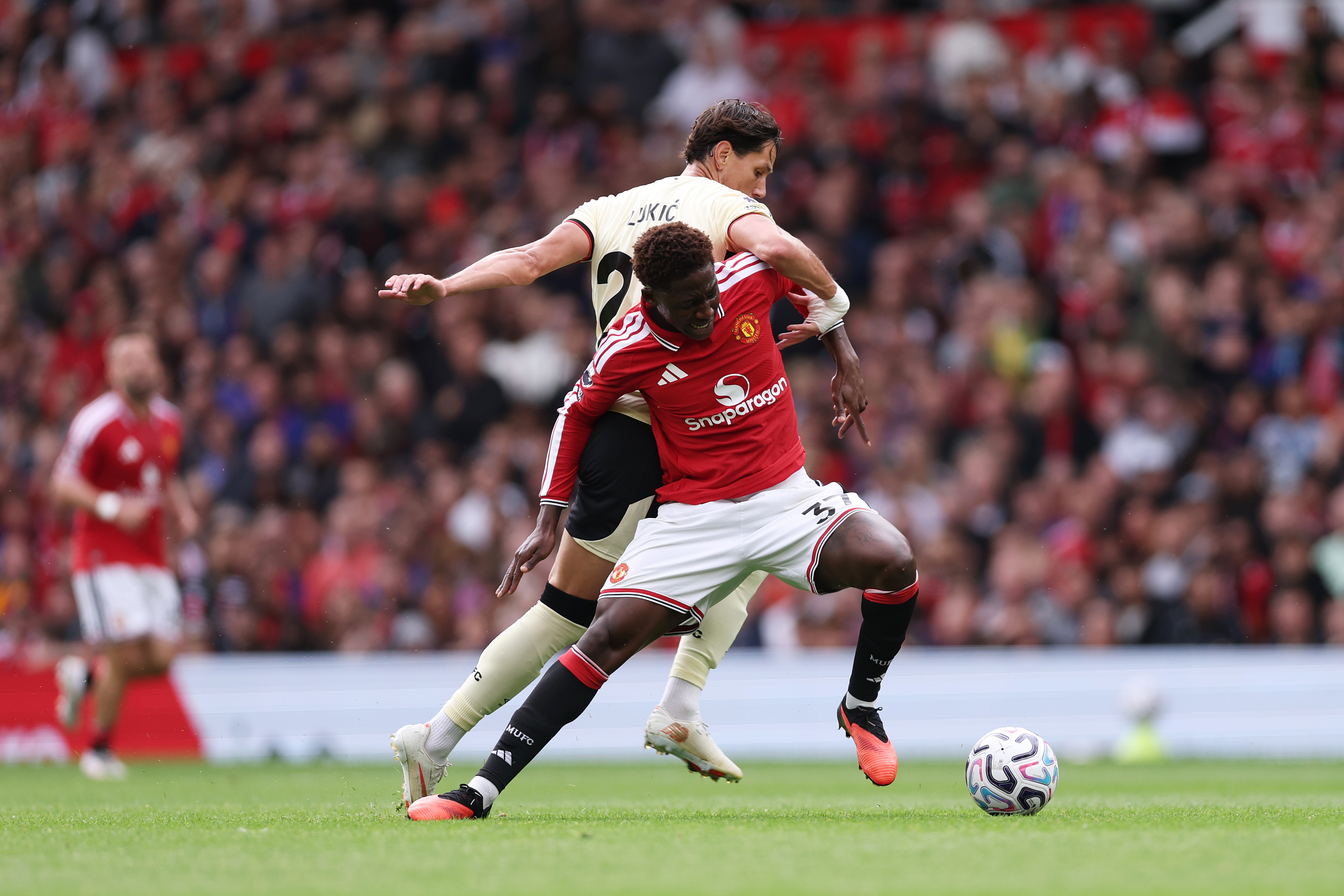 MANCHESTER, ENGLAND - AUGUST 30: Kobbie Mainoo of Manchester United is challenged by Sasa Lukic of Ipswich Town during the Premier League 2026/27 match between Manchester United and Ipswich Town at Old Trafford on August 30, 2026 in Manchester, England.