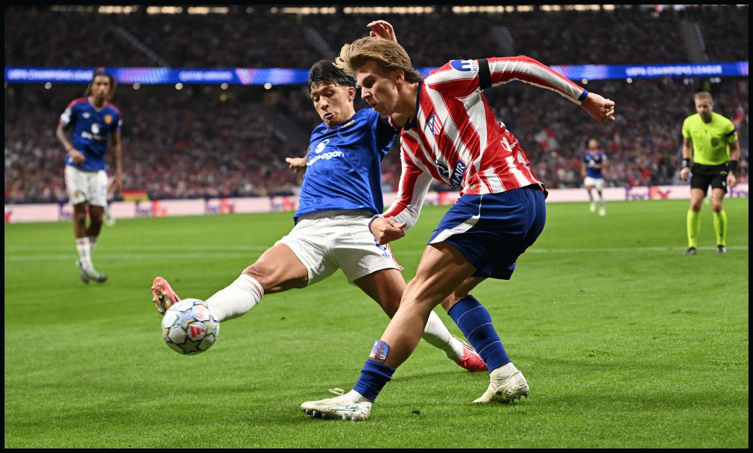 MADRID, SPAIN - OCTOBER 13: Pablo Barrios of Atletico Madrid crosses the ball under pressure from Lisandro Martinez of Manchester United during the UEFA Champions League 2026/27 League Phase MD2 match between Atletico de Madrid and Manchester United at Estadio Metropolitano on October 13, 2026 in Madrid, Spain